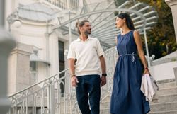 Nach einer Veranstaltung verlässt ein Paar die historische Sommerarena Baden. Sie schlendern fröhlich die imposanten Stufen des beeindruckenden Bauwerks hinab.