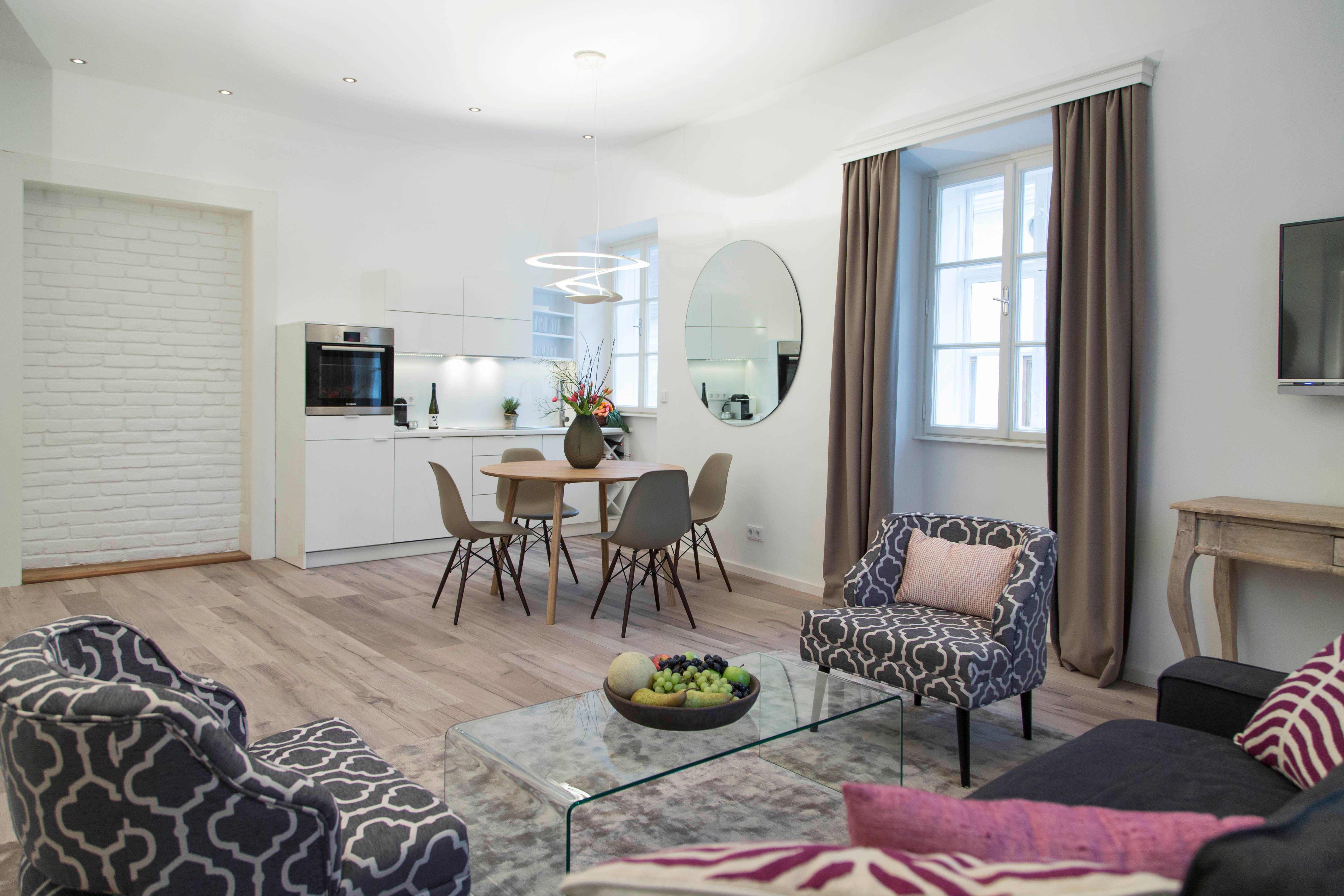 Moderní obývací pokoj s kuchyní, jídelním stolem a stylovým nábytkem.