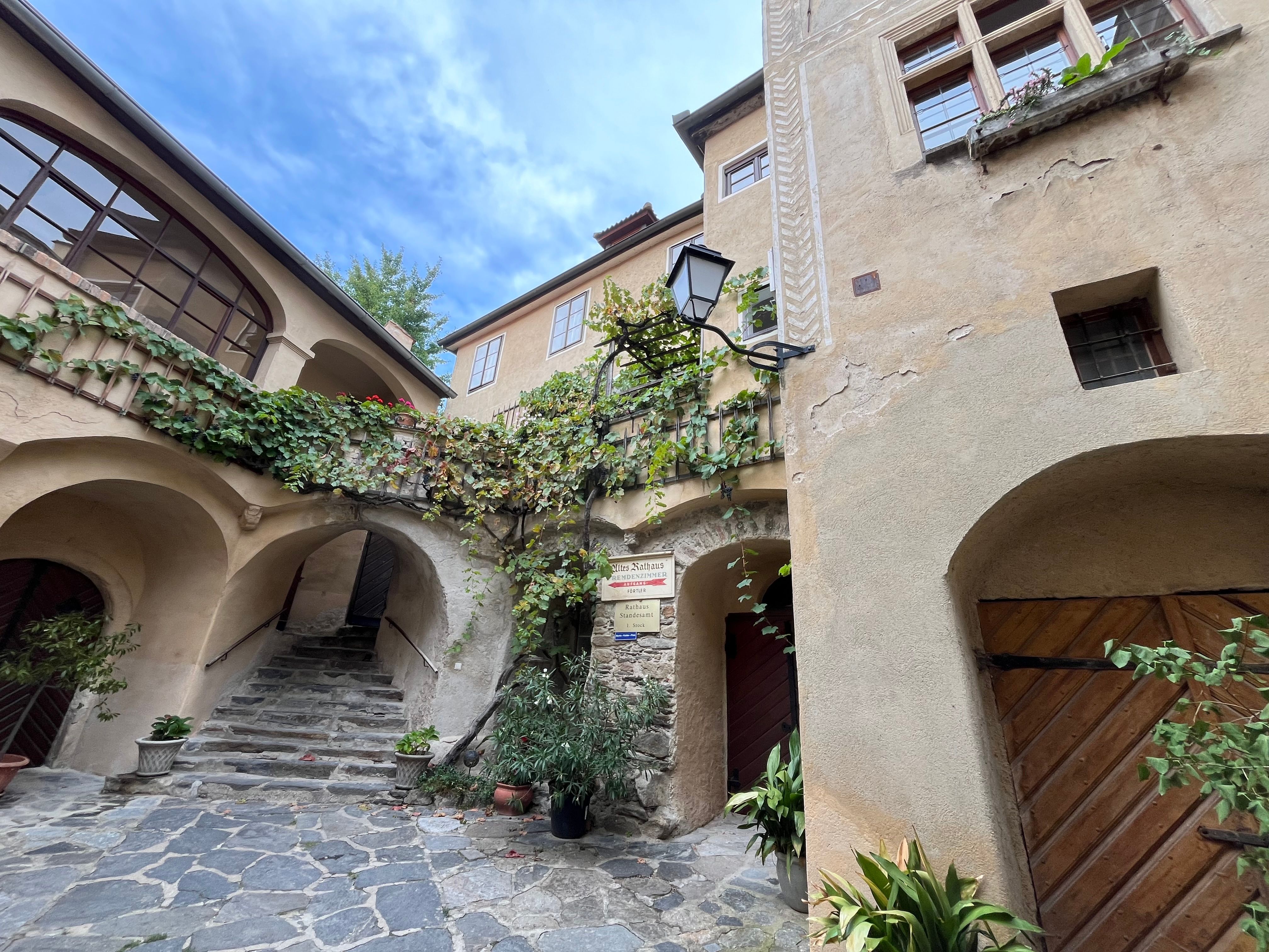 Historická budova s arkádami a rostlinami v Dürnsteinu.