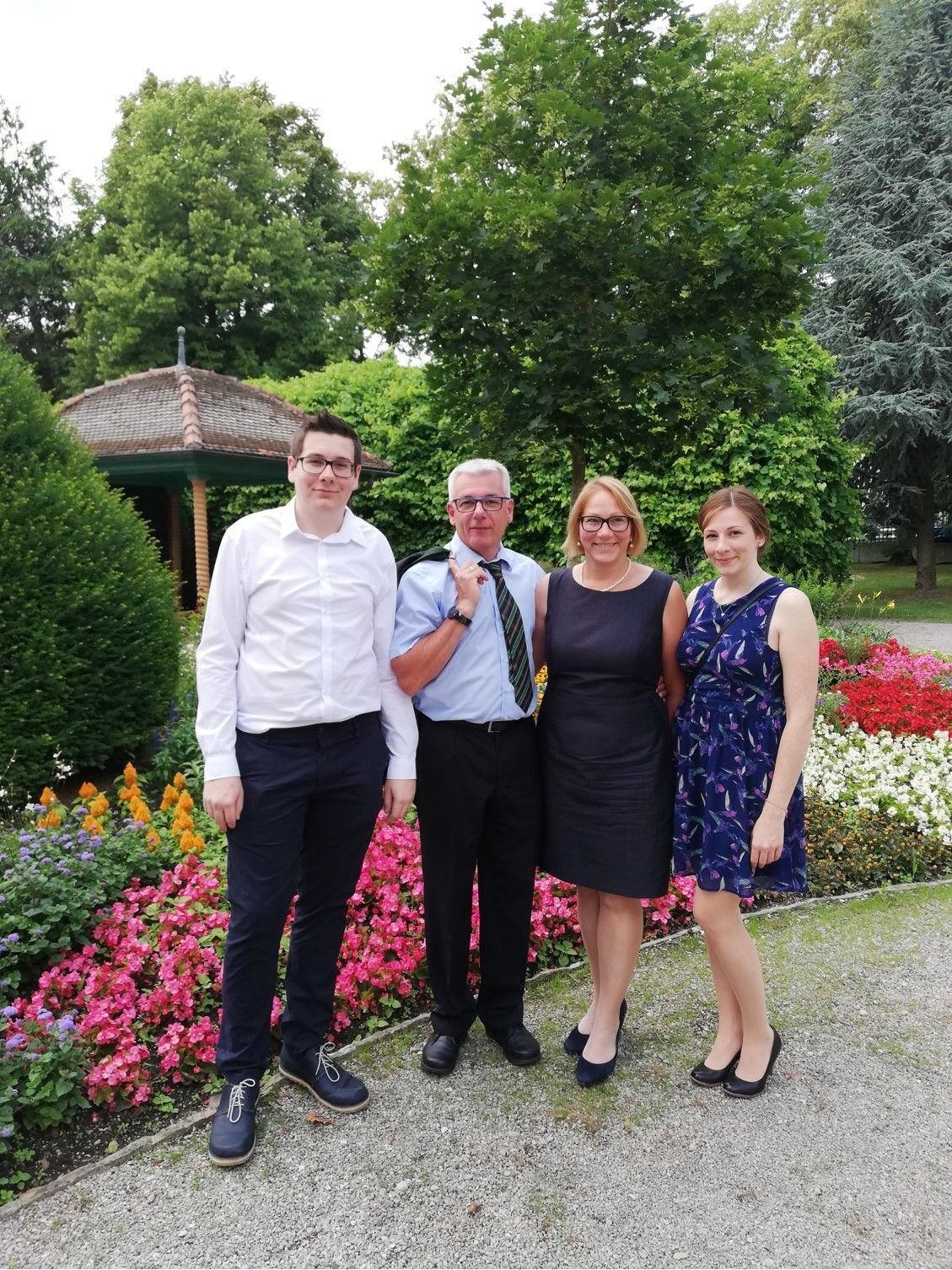 Čtyři lidé stojí před venkovním záhonem.