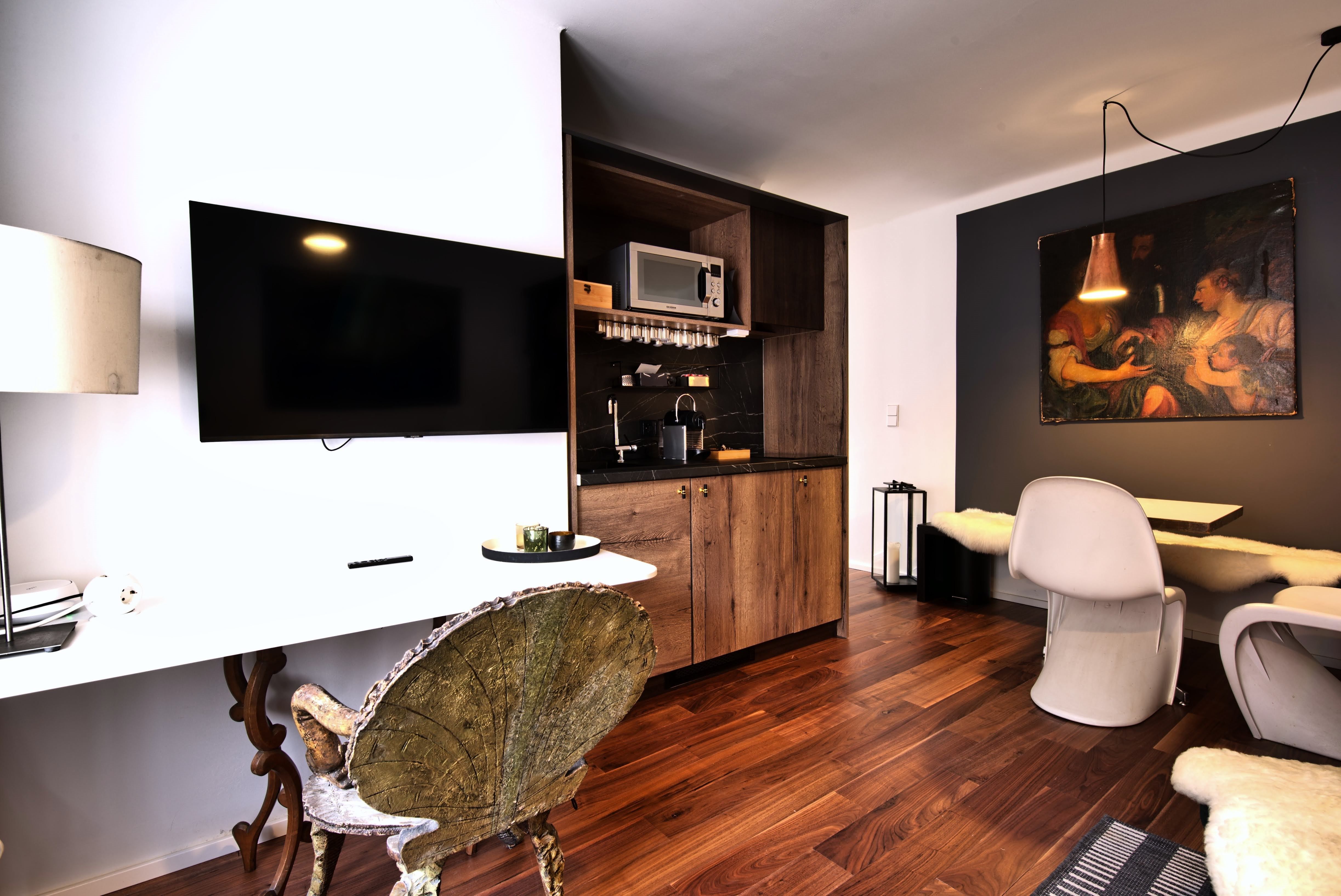 Moderní kuchyně s dřevěnými skříňkami, TV s plochou obrazovkou a jídelním koutem.