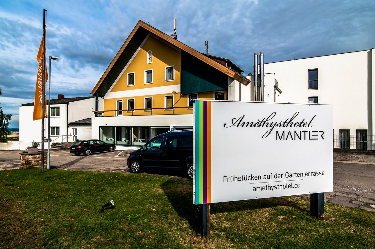 Vnější pohled na Amethysthotel Mantler s parkovištěm a nápisem.