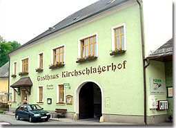 Tradiční hostinec se zelenou fasádou a nápisem "Gasthaus Kirschlagerhof".