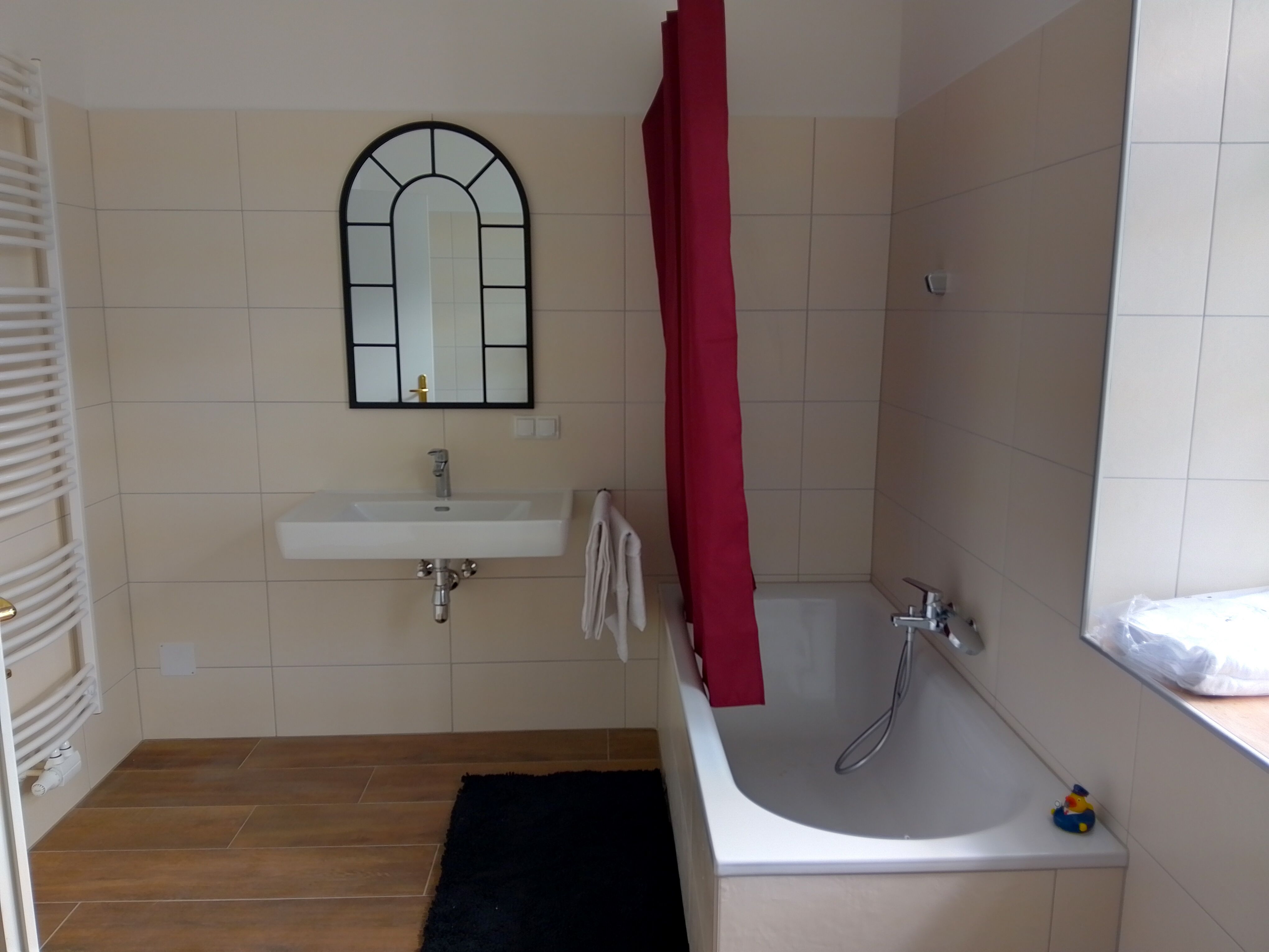 Moderní koupelna s vanou, umyvadlem a zrcadlem.