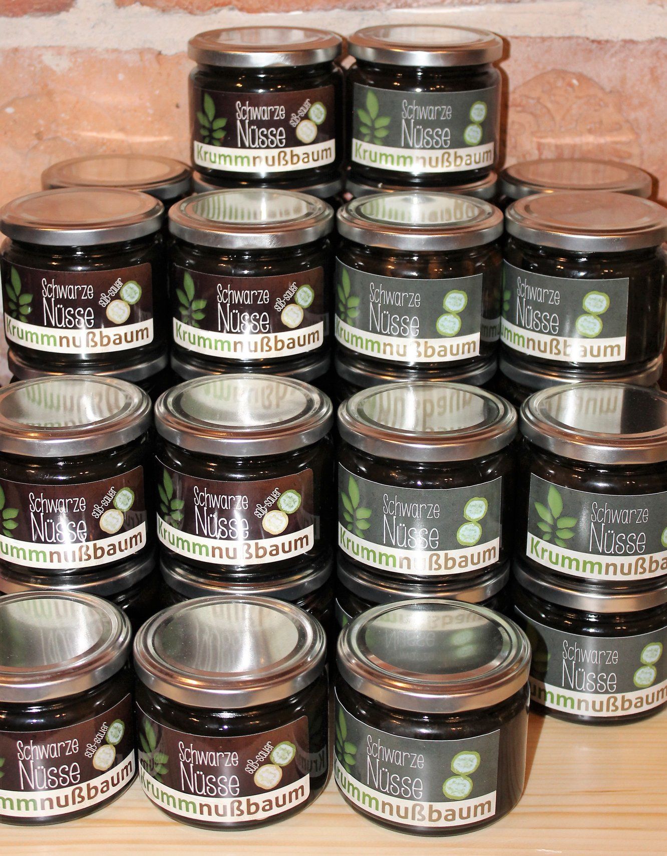 Na stole je naskládáno několik sklenic s nápisem "Schwarze Nüsse Krummnußbaum".
