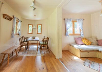 Pohled do interiéru útulného modulárního domu s jídelním koutem a posezením.