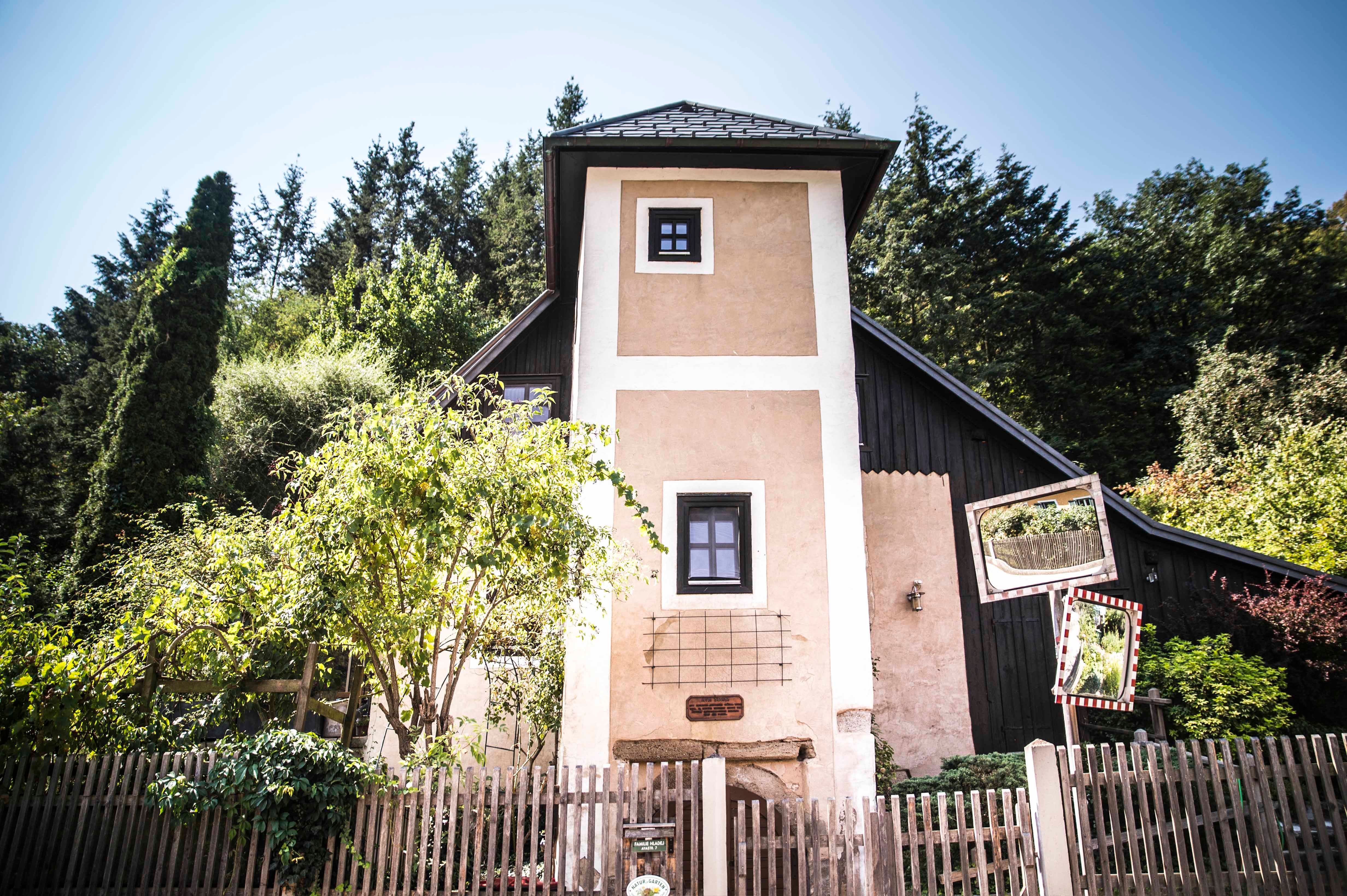 Malá věž s dřevěným plotem a stromy v pozadí.