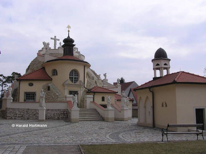 Kostel v Maria Lanzendorf se sochami a zvonicí.