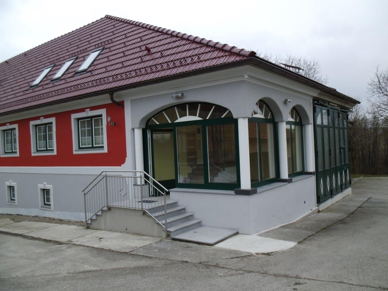 Moderní budova s červenou střechou a červenou fasádou.