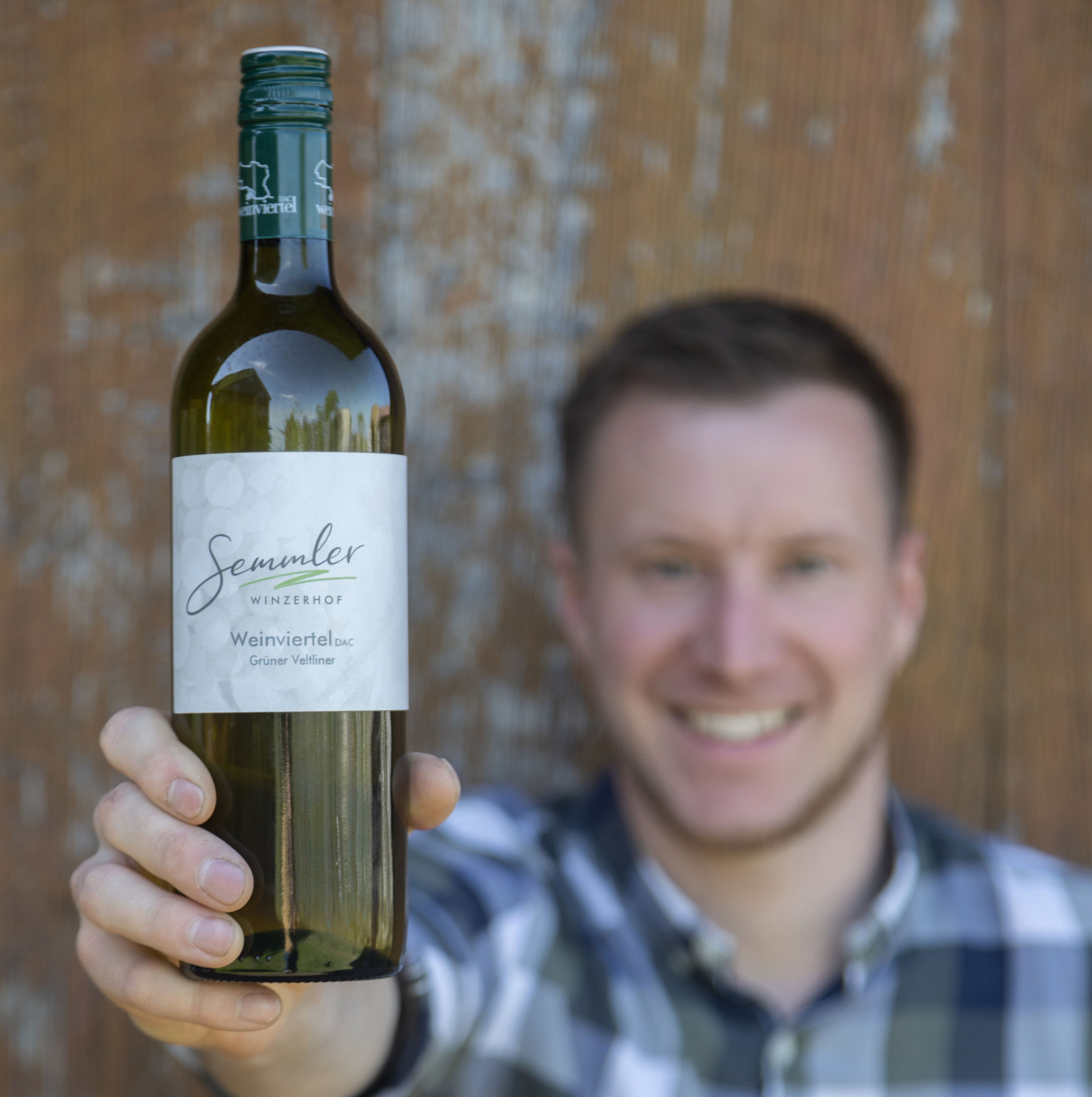 Muž drží před kamerou láhev vína z vinařství Winzerhof Semmler.