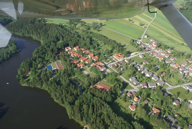 Letecký pohled na golfové hřiště a jezero se sousedním sídlištěm.