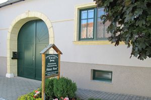 Vchod do penzionu se zelenou bránou a nápisem "Haus Resi".