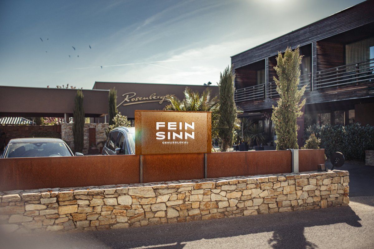 Vstup do Feinsinn Genusslokal s moderní architekturou a rostlinami.