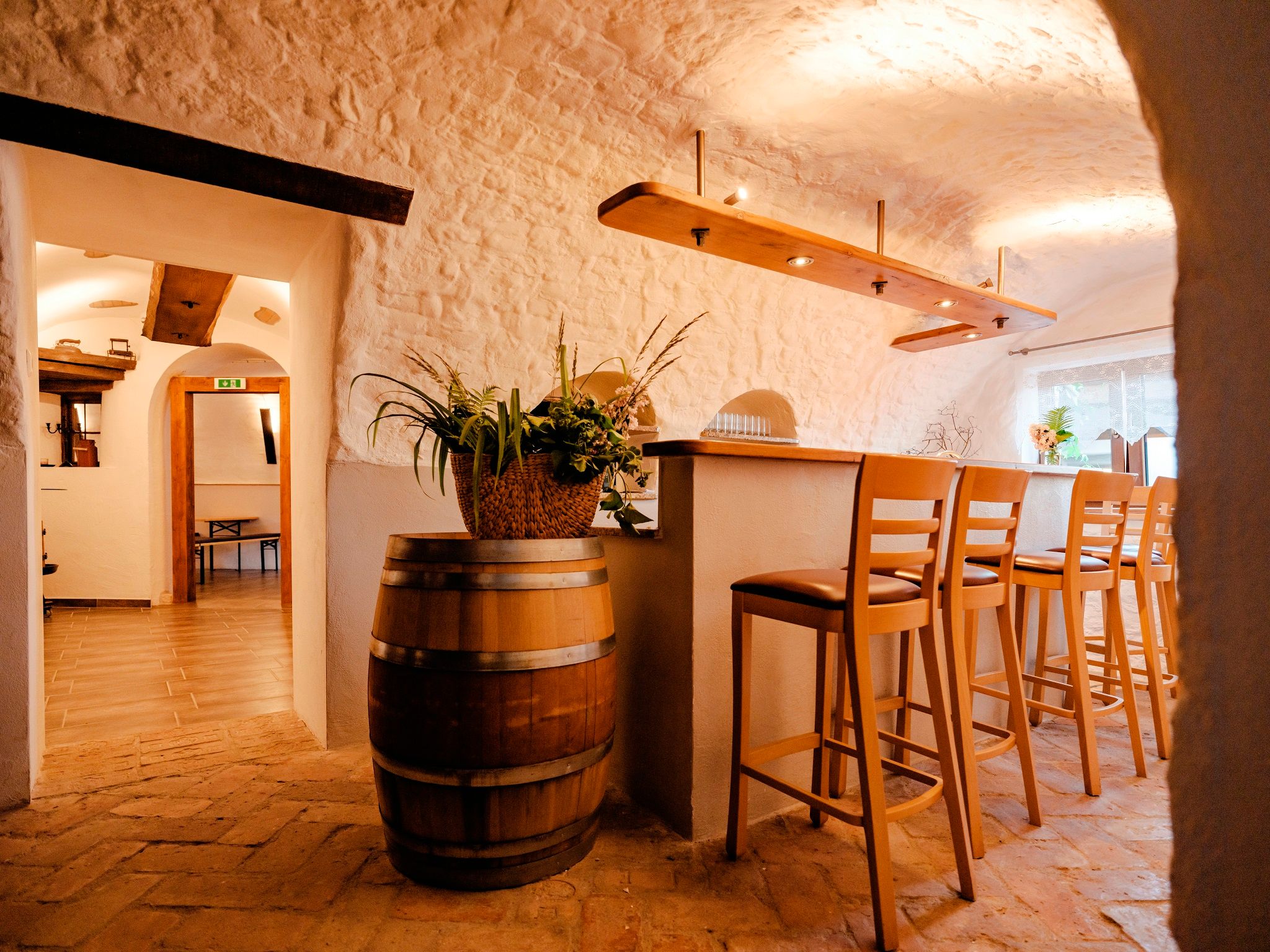 Útulný salonek s barovými stoličkami a rustikálním nábytkem.