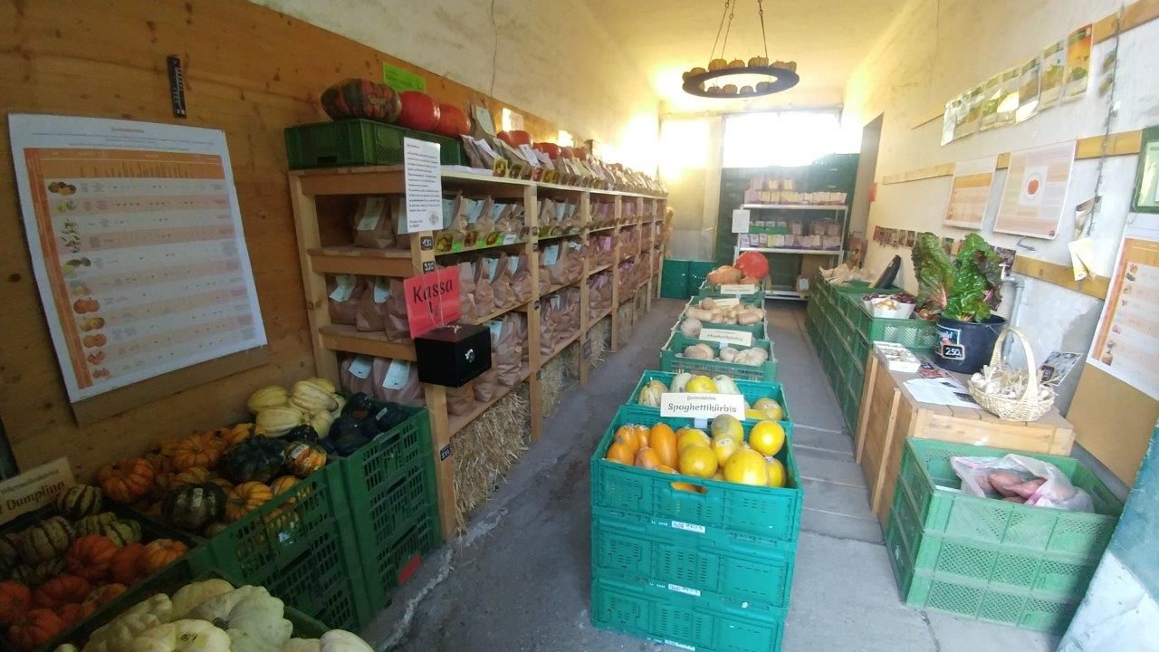 Malý farmářský obchod s regály plnými zeleniny a produktů.