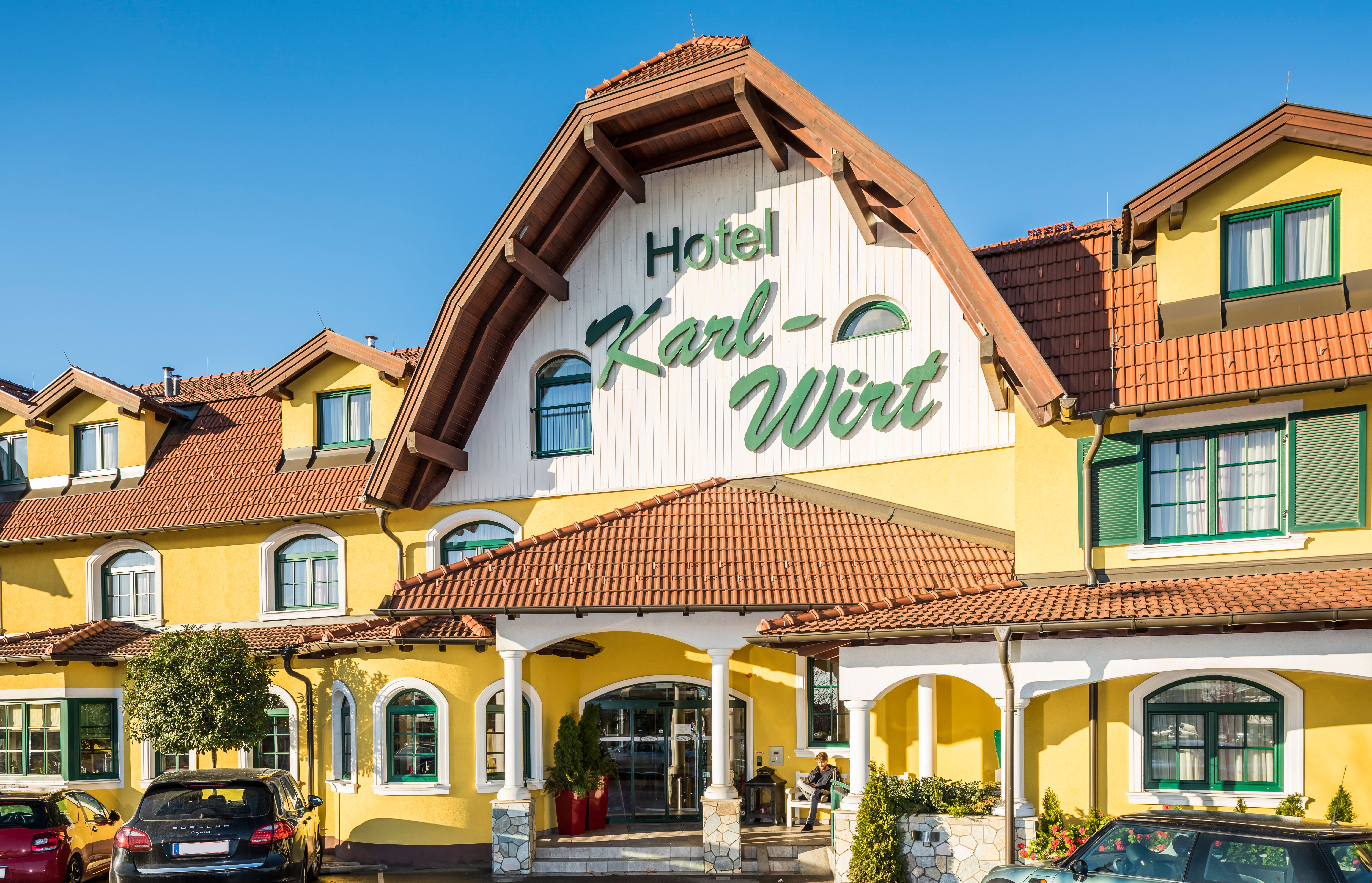 Žlutá hotelová budova s nápisem "Hotel Karl-Wirt" na štítu.