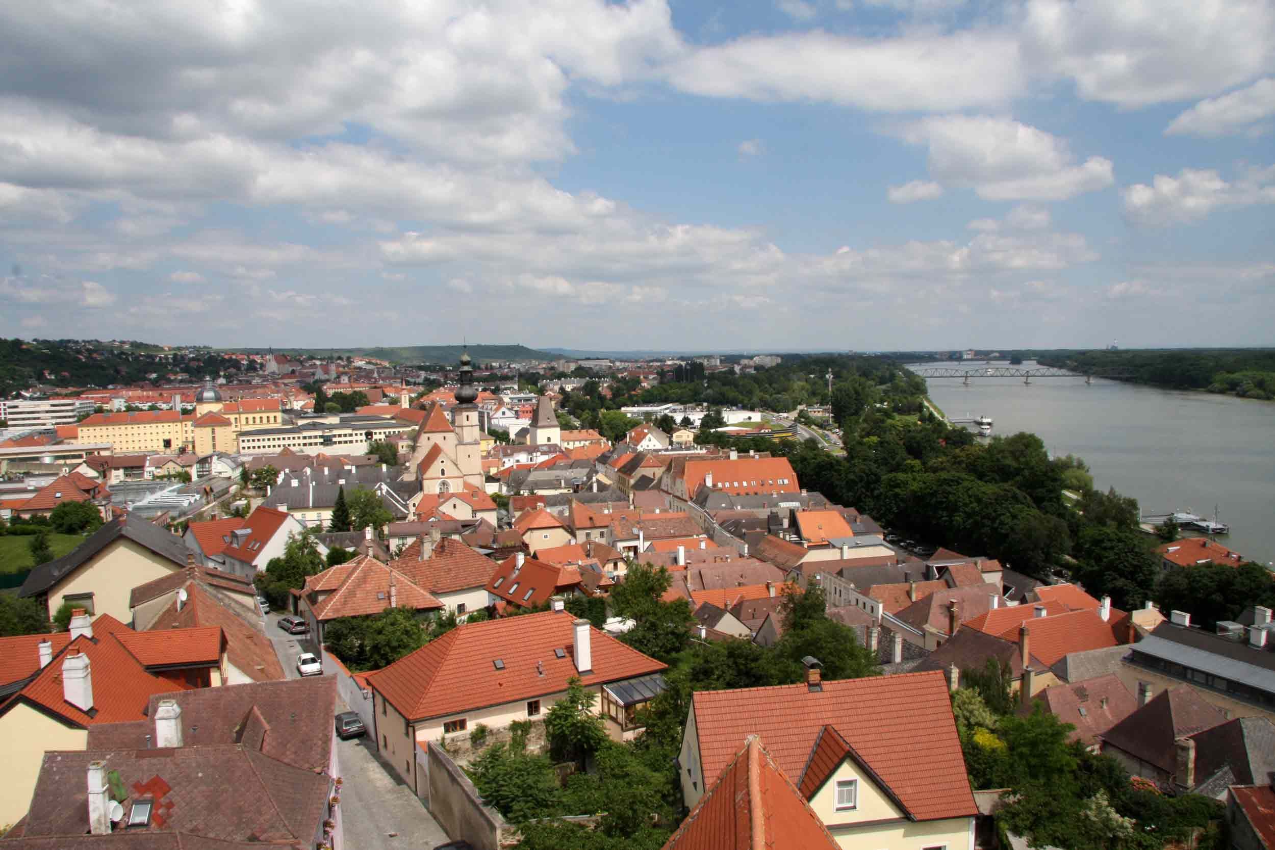 Panoramatický pohled na střechy Kremže s řekou v pozadí.