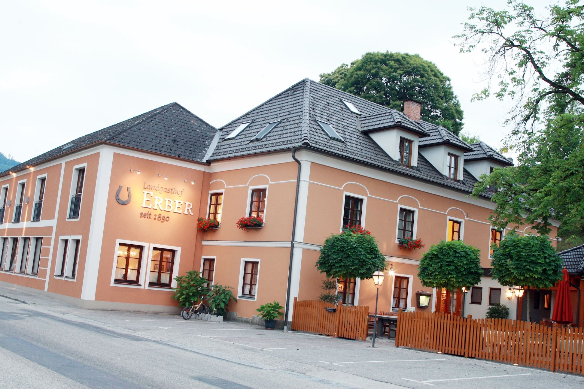 Vnější pohled na Landgasthof Erber s oranžovou fasádou a květinovými truhlíky.