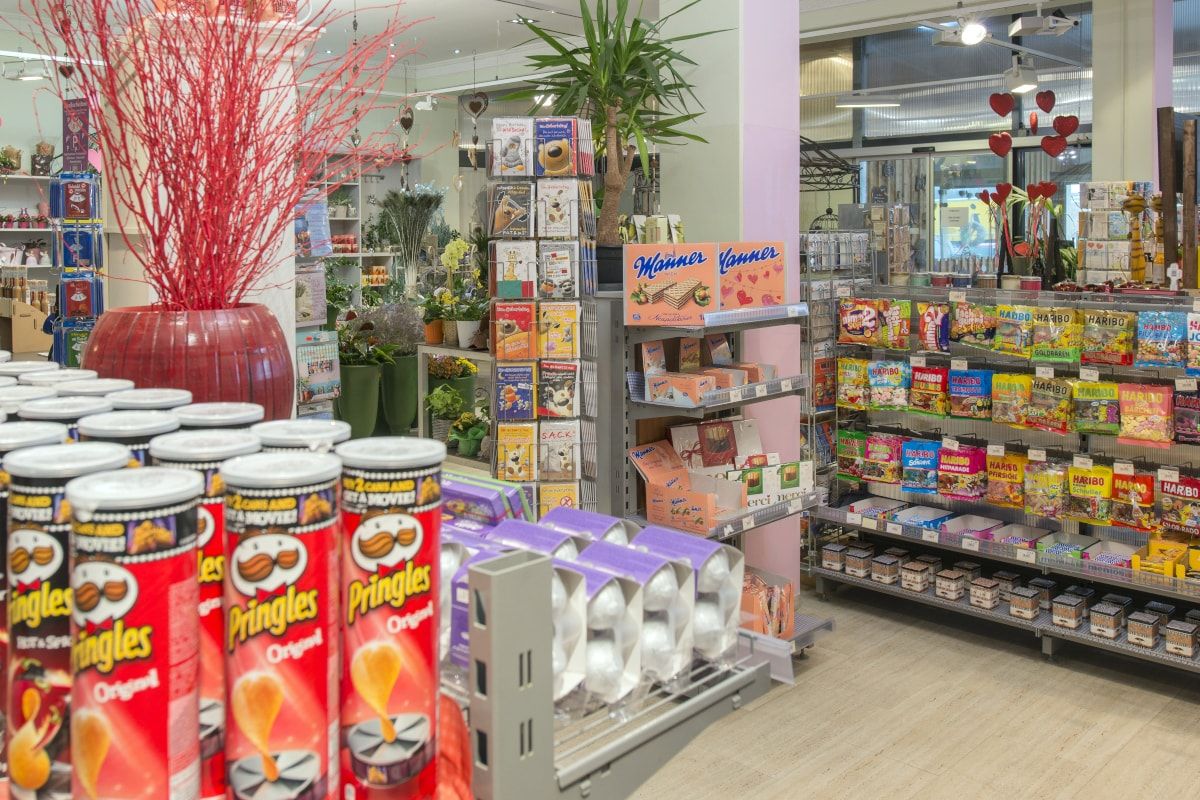SHop se spoustou sladkostí. V popředí jsou naskládané chipsy.
