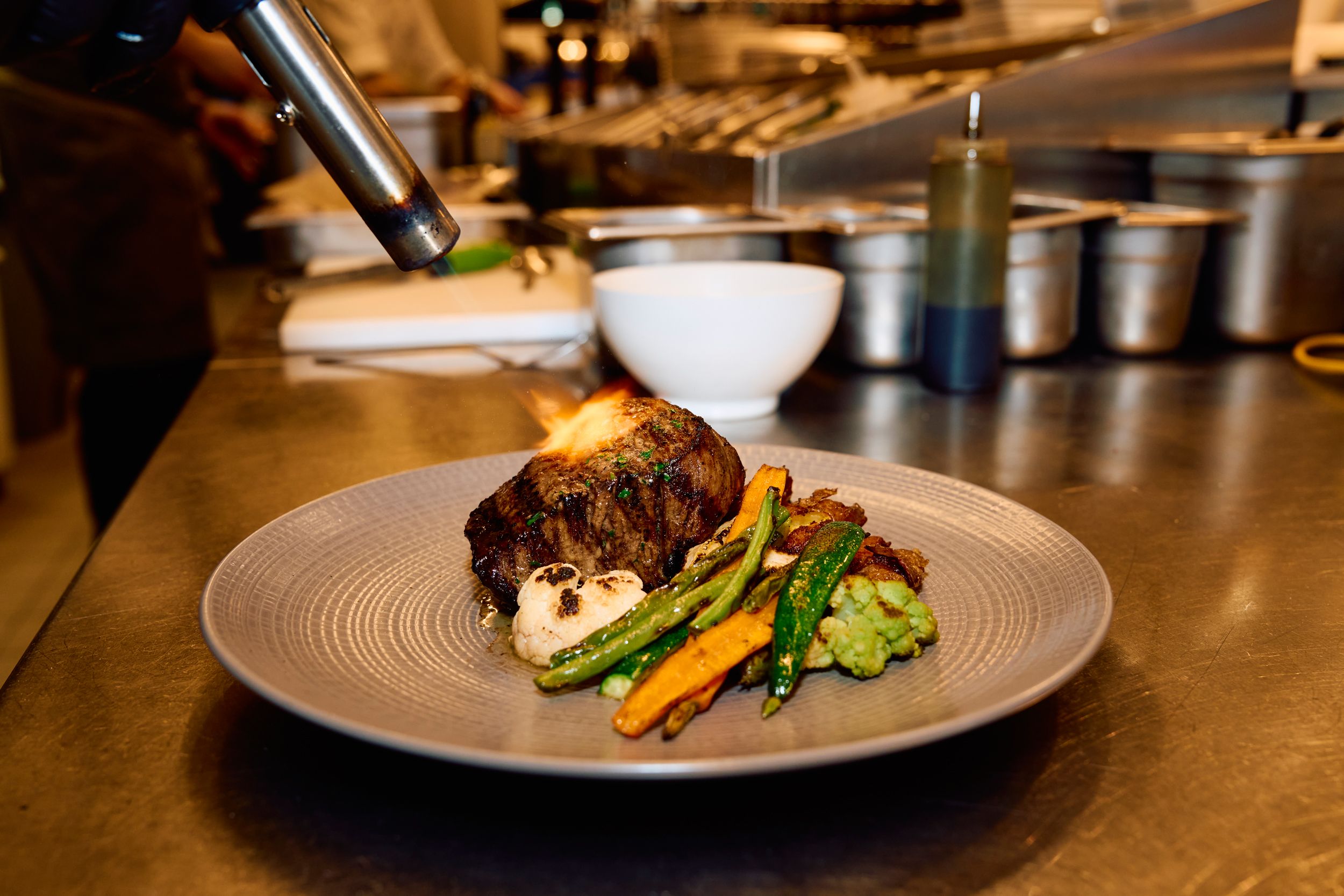 Wolfgang Puck Kitchen + Bar, maso se flambuje na talíři