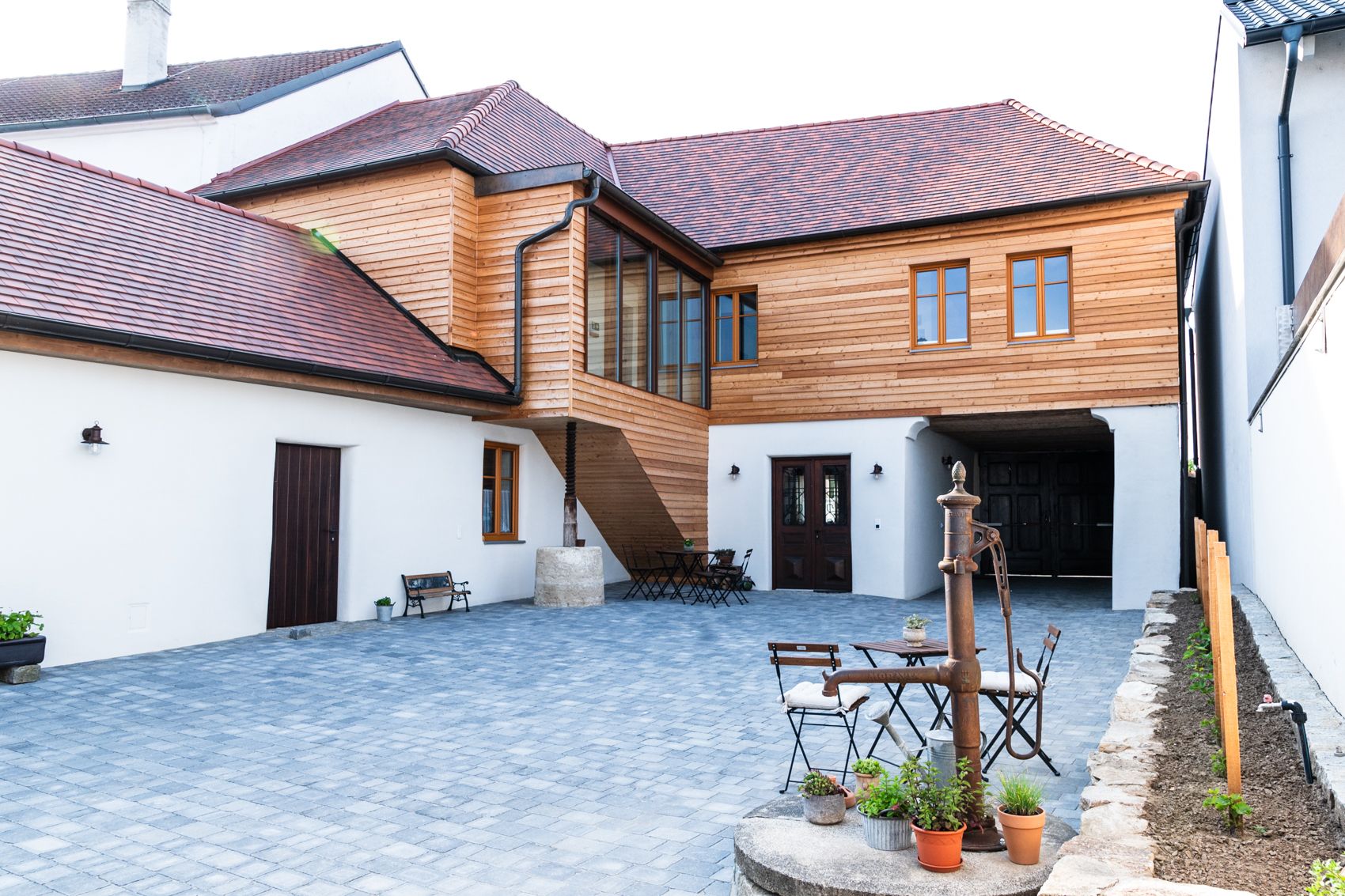 Vnitřní dvůr penzionu s dřevěnými prvky a dlážděnou podlahou.
