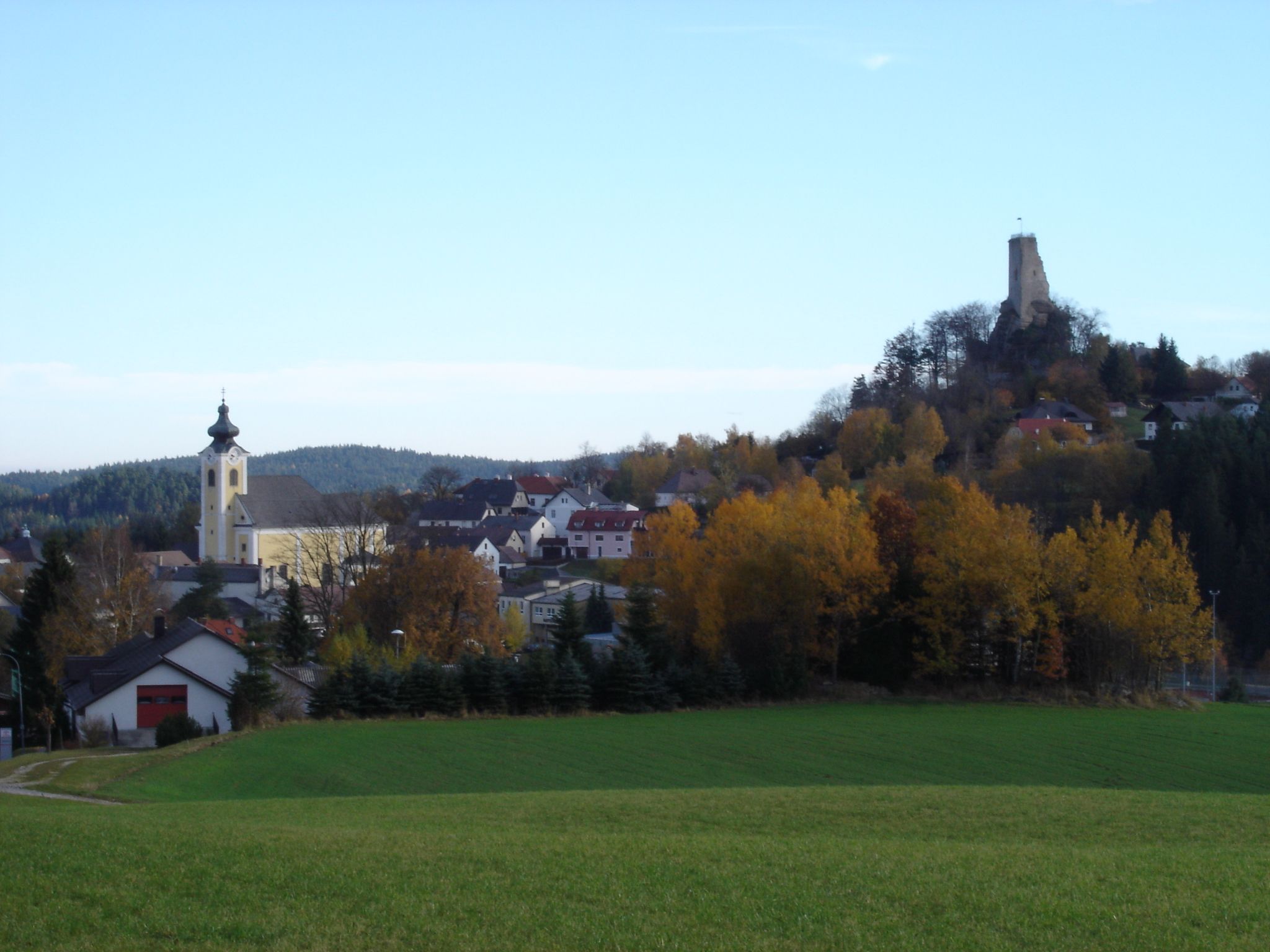 Pohled na krajinu Arbesbachu s kostelem a zříceninou hradu.