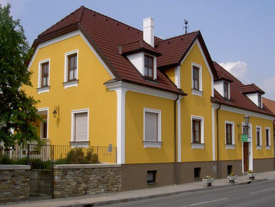 Žlutý rodinný dům s červenou střechou
