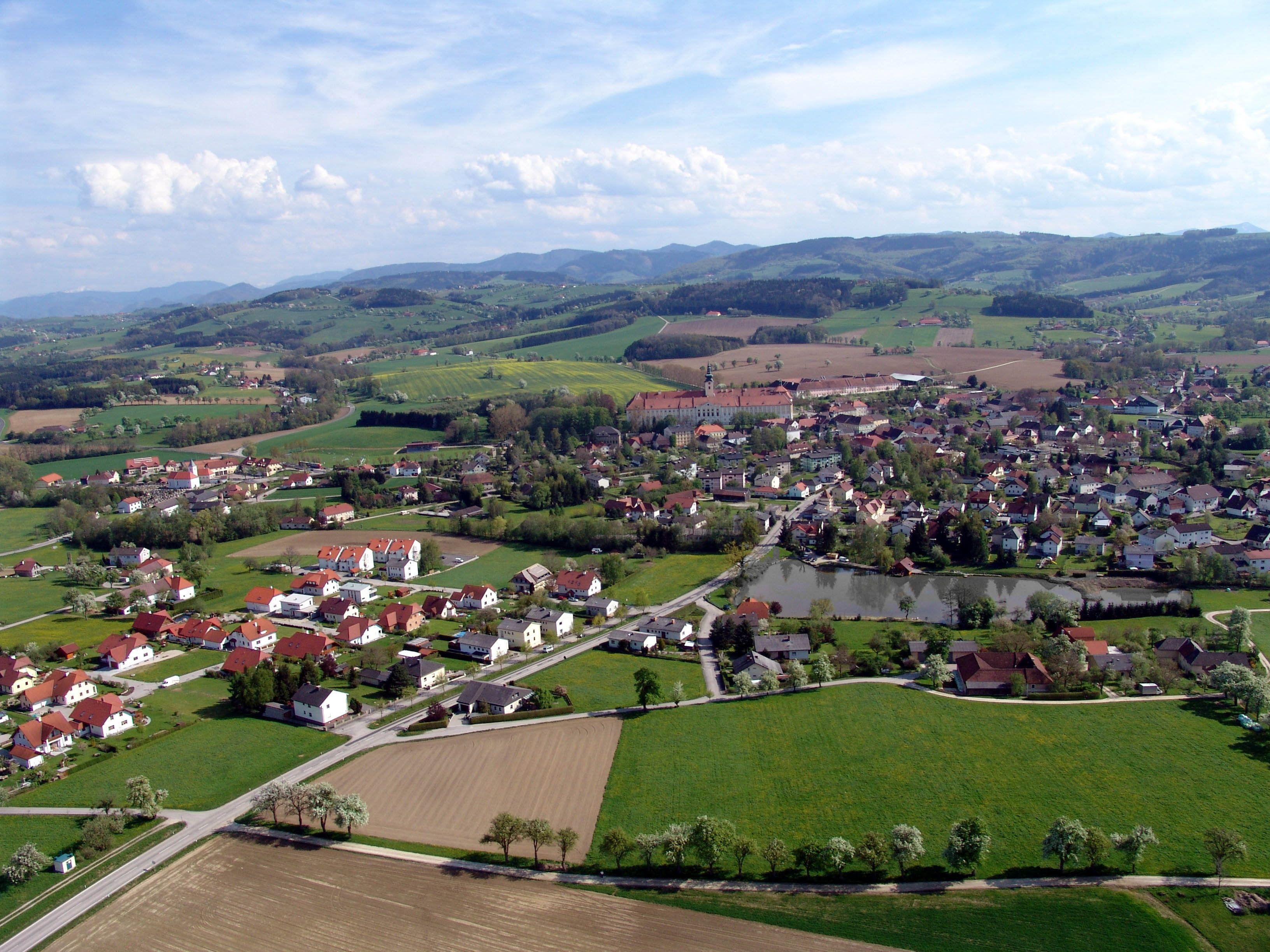 Letecký pohled na Seitenstetten s poli, domy a kopci v pozadí.