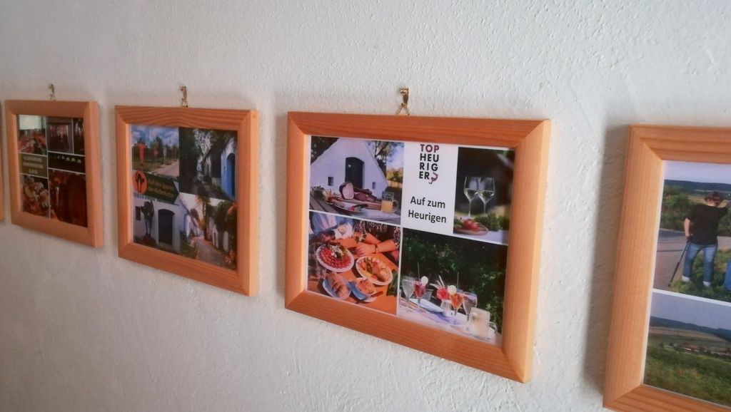 Řada rámečků s fotografiemi na bílé zdi.