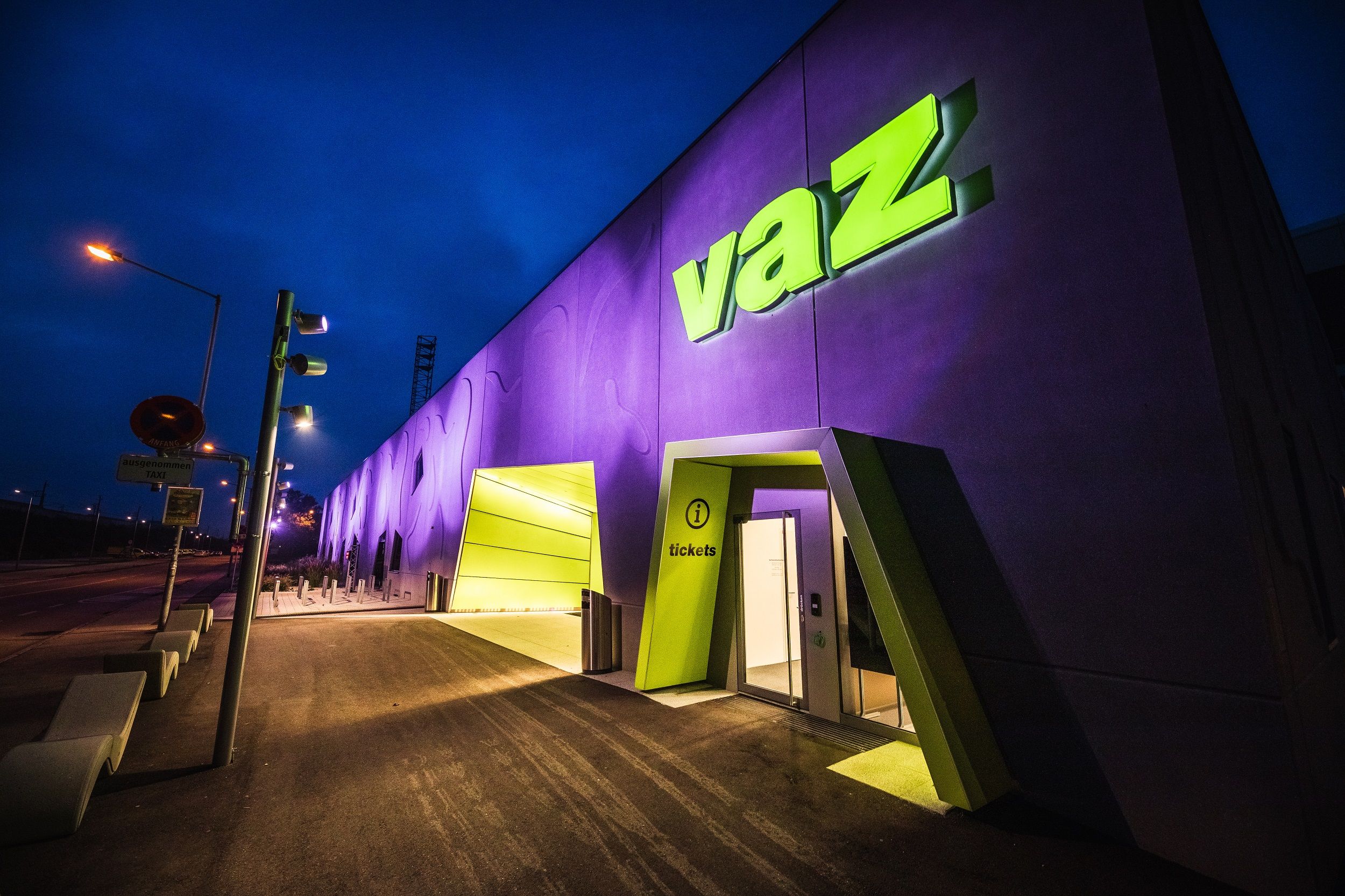 Vchod do VAZ St. Pölten v noci s osvětleným nápisem.