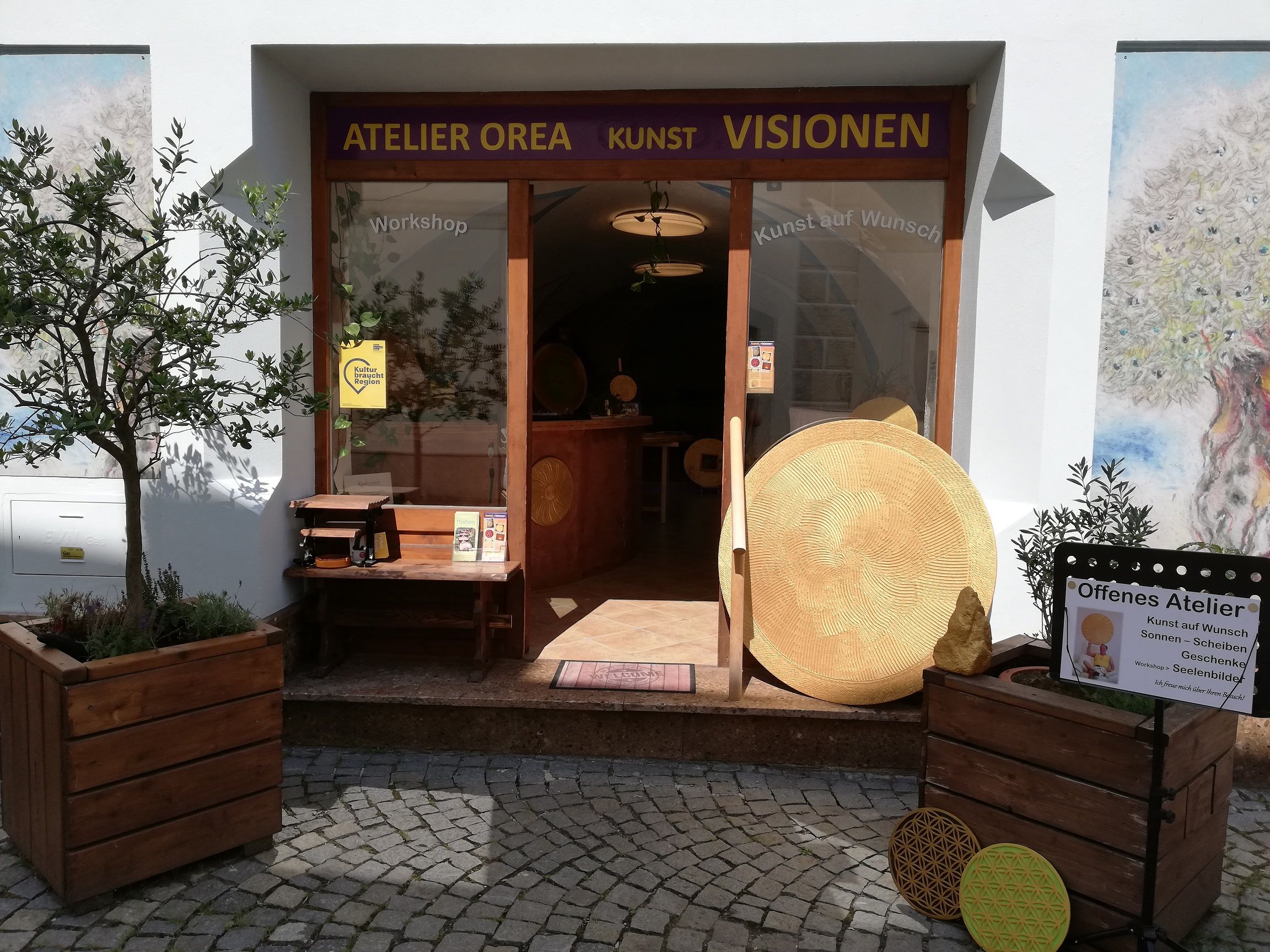 Vstup do ateliéru Orea s uměleckými díly a rostlinami.