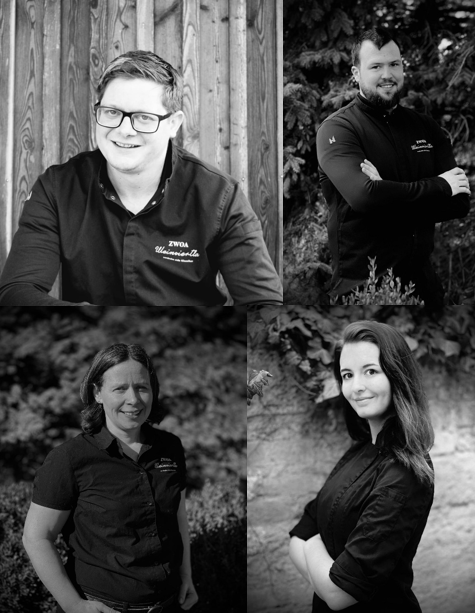 Čtyři lidé na černobílých portrétech, usmívající se a pózující v pracovním oblečení.