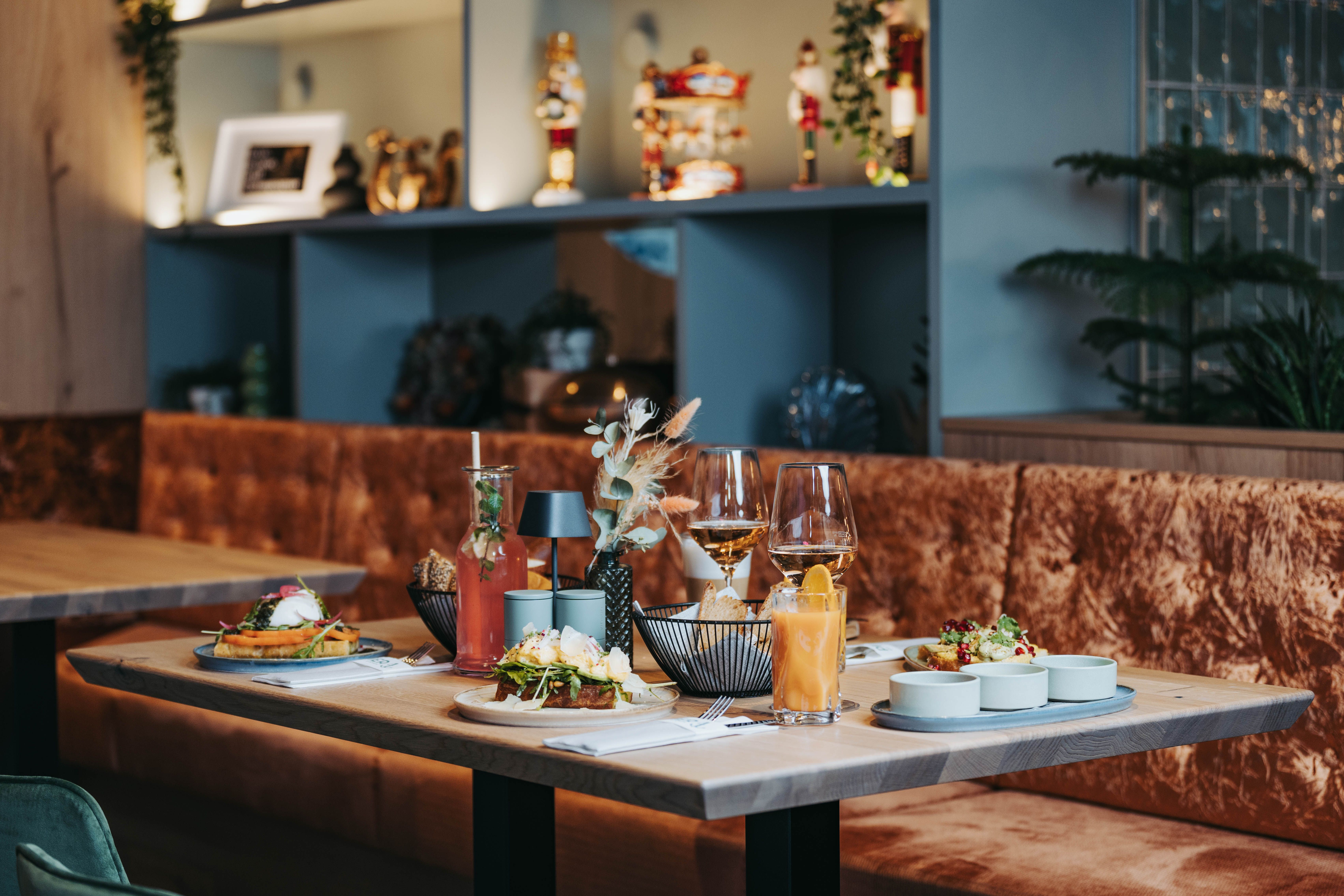 Prostřený stůl s jídlem a nápoji ve stylové restauraci.