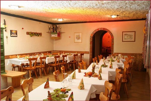 Útulná jídelna s dřevěným nábytkem a prostřenými stoly.