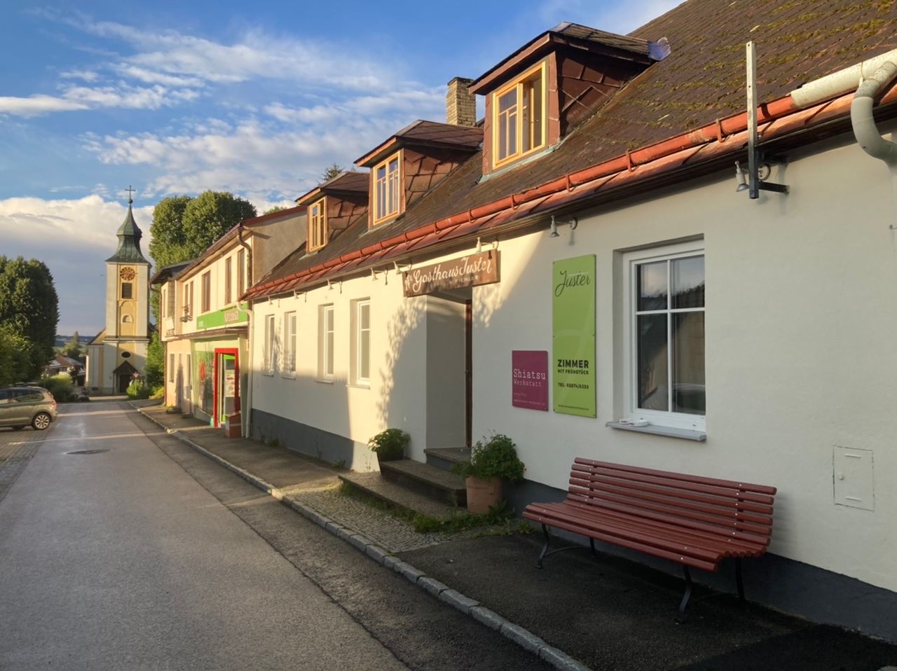 Exteriérový pohled na hostinec Juster stage s kostelem v pozadí.
