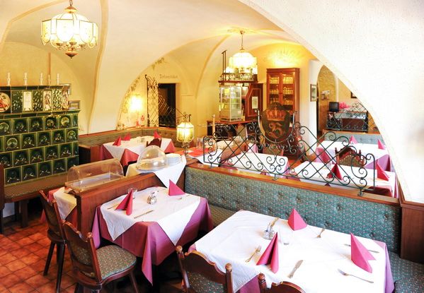 Útulná restaurace s prostřenými stoly a tradiční výzdobou.