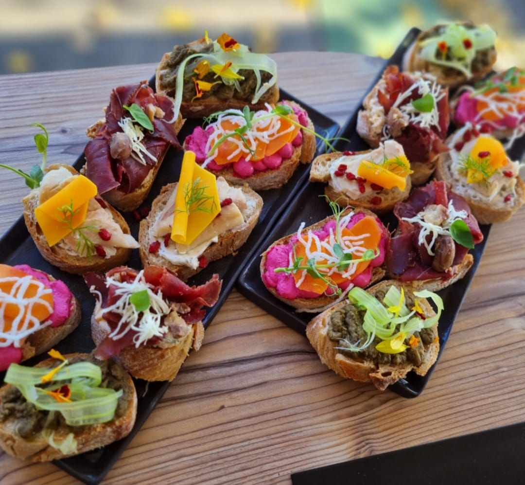 Různé sendviče na dvou černých talířích.