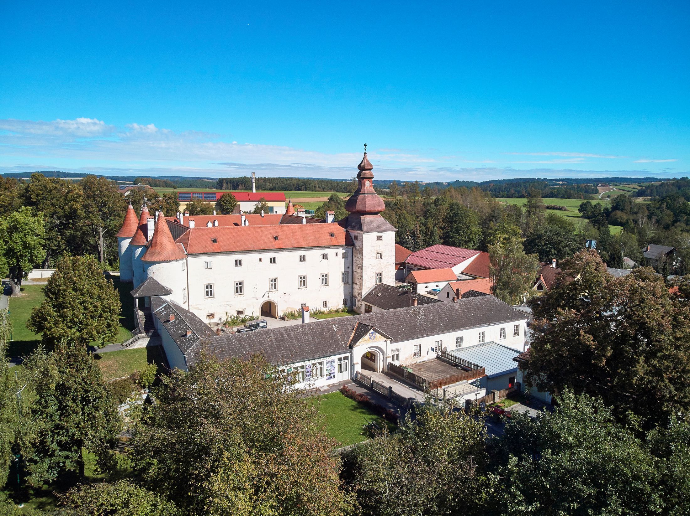 Letecký pohled na hrad Dobersberg s červenou střechou a okolní krajinou.