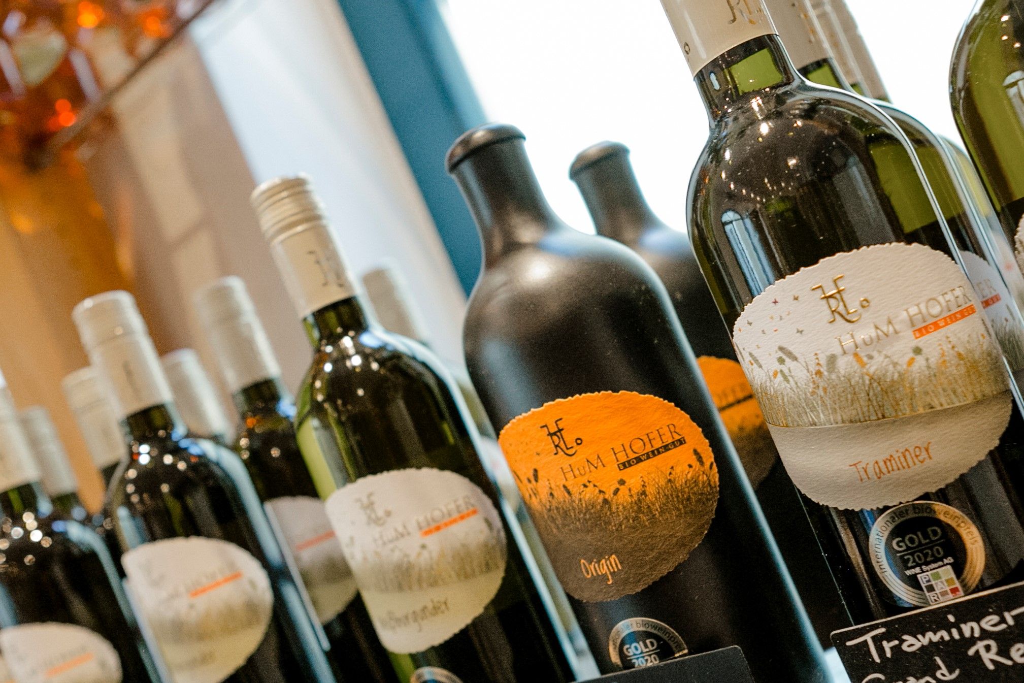 Detailní záběr na láhve s vínem označené značkou Hum Hofer.