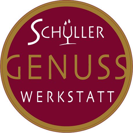 Logo Schüller Genuss Werkstatt s červeným pozadím a zlatým písmem.