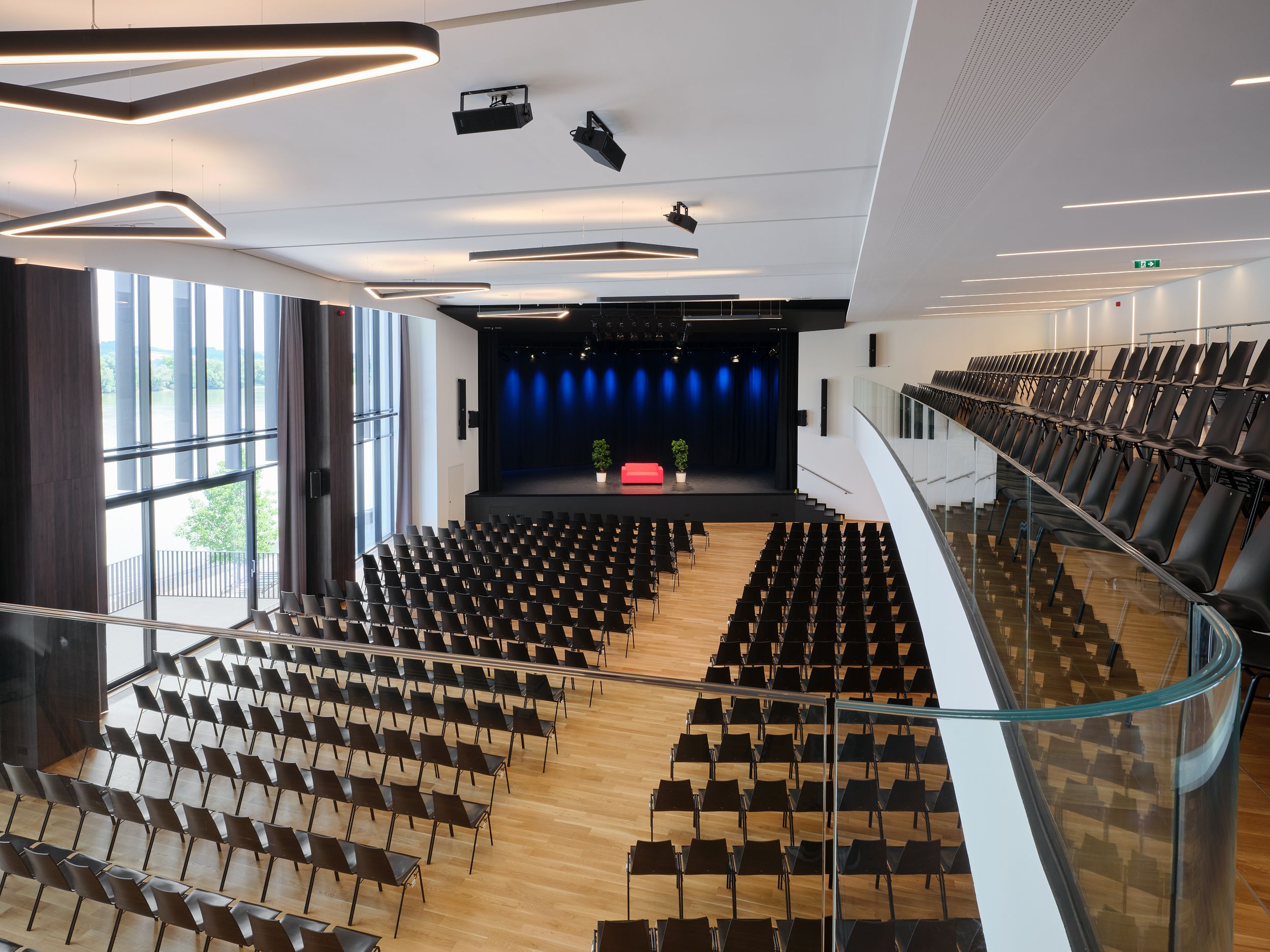 Pohled do interiéru Stadthalle Ybbs s prázdnými řadami sedadel a jevištěm.