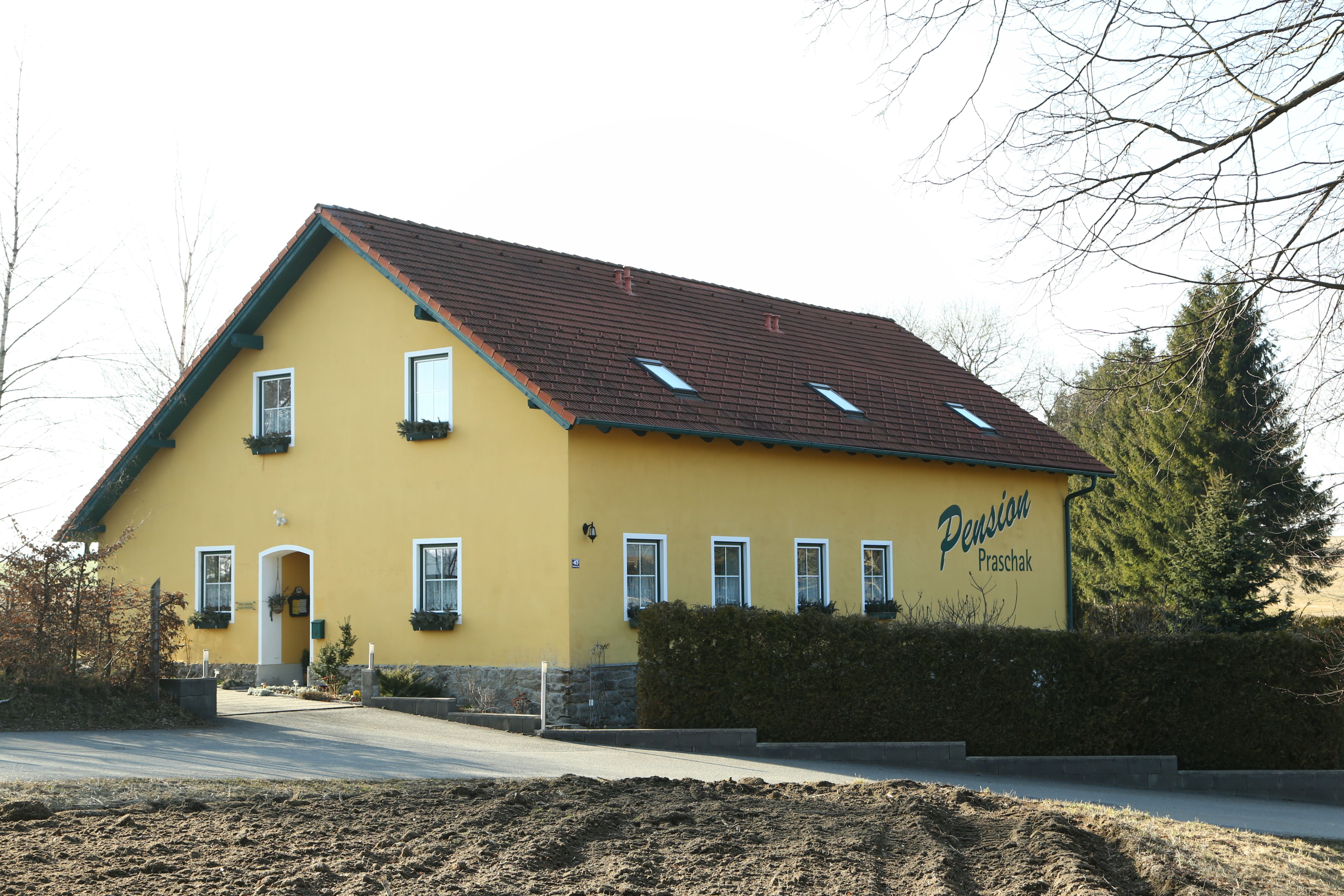 Žlutá budova s označením "Pension Praschak".