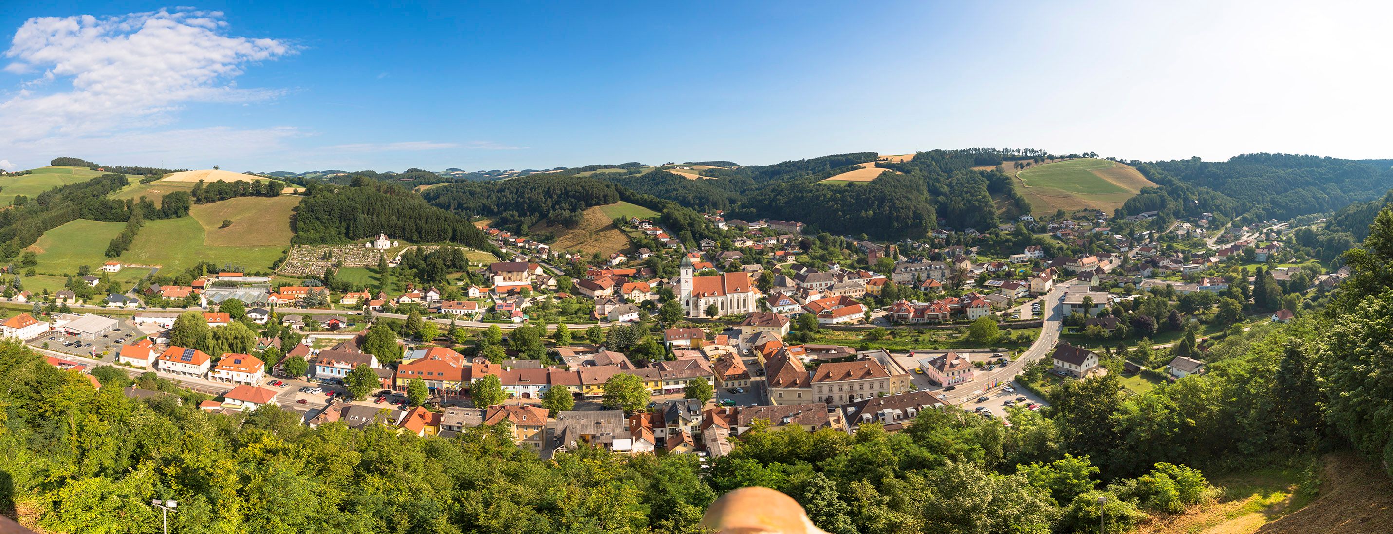 Panoramatický pohled na Kirchschlag in der Buckelige Welt, obklopený kopci a lesy.