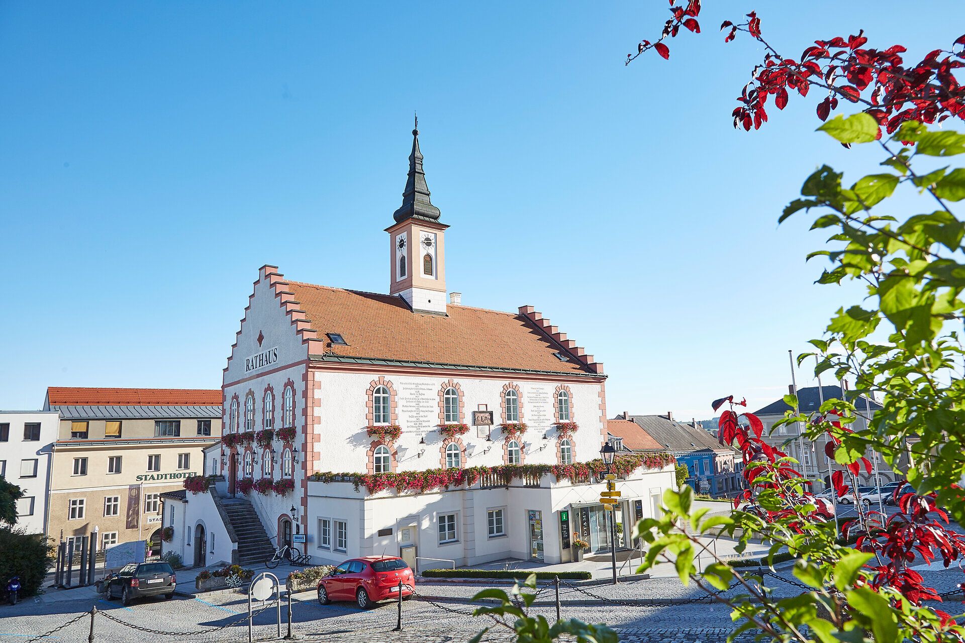 Půvabné opevněné město září v teplém odpoledním světle. Historická radnice obklopená kvetoucími rostlinami vás zve k poznávání historie a kultury tohoto malebného kraje.