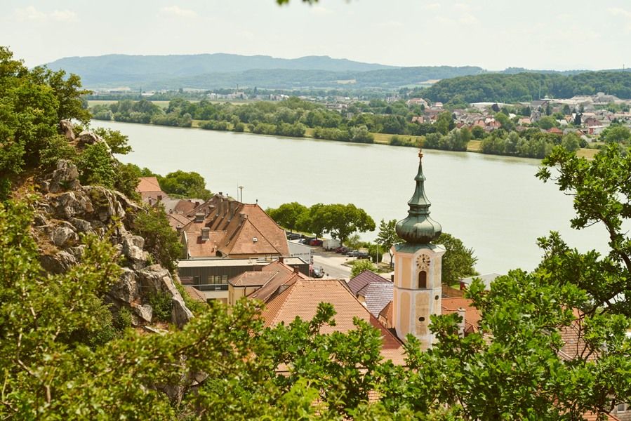 Pohled na Marbach na Dunaji v létě s kostelem a řekou.