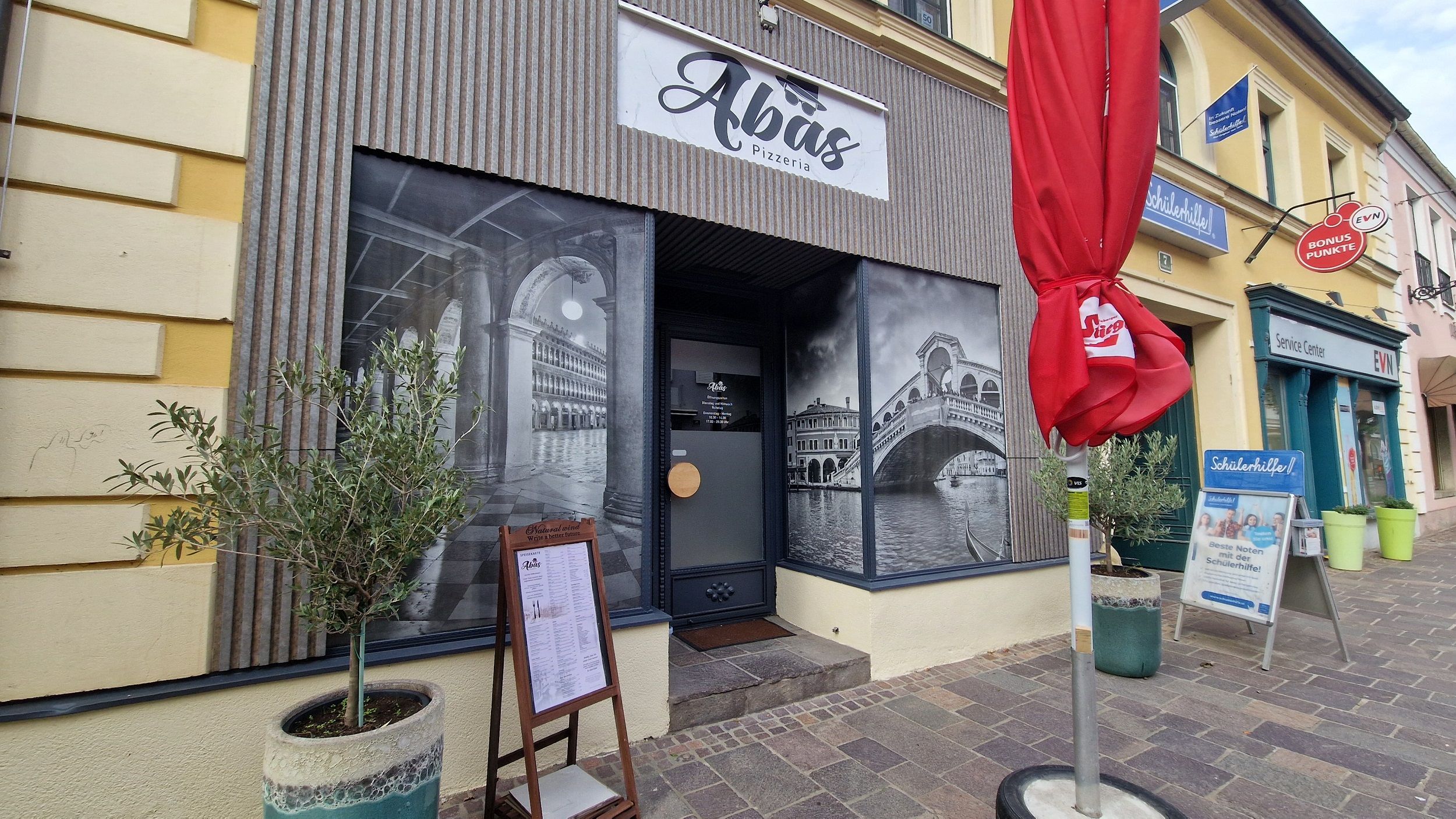 Restaurace zvenčí s nápisem nad dveřmi 