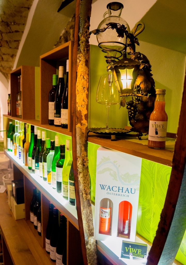 Police s lahvemi vína a dekoracemi ve vinárně.