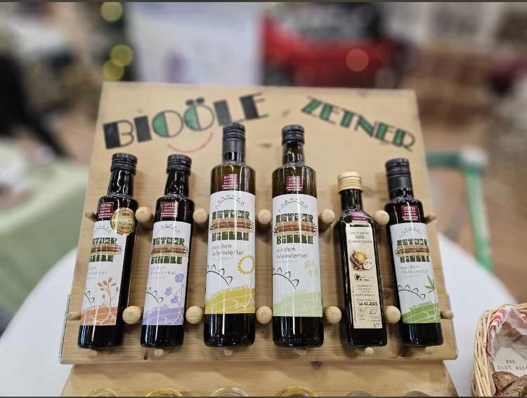 Pět lahví bio oleje na dřevěném stojanu s nápisem "Bioöle Zeiner".