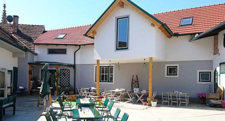 Vnitřní dvůr hostince se stoly a židlemi venku.