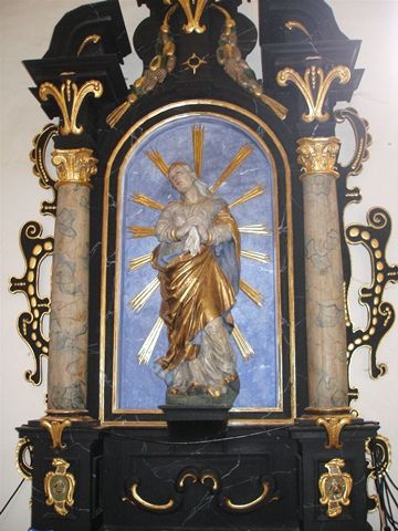 Barokní socha Bolestné Madony v bohatě zdobeném oltáři.